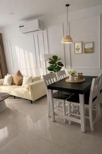 a living room with a table and a couch at Hue Oi Homestay - Spacious 3-Bedroom Apartment with Balcony & Pool in Hue