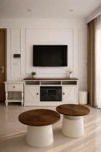 a living room with a tv and a coffee table at Hue Oi Homestay - Spacious 3-Bedroom Apartment with Balcony & Pool in Hue