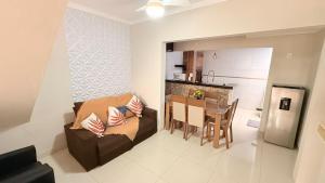 a living room and kitchen with a couch and a table at Sobrado de luxo em condomínio in Araçatuba