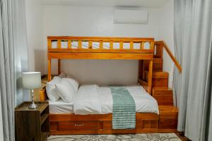 a bedroom with a bunk bed and a lamp at Casa Mutya in Dauis