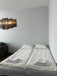 a bed with white sheets and towels on it at Kerulis Apartments in Vilnius