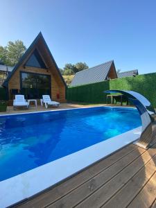 a swimming pool in front of a house at Evergreen Lodge in Çakırlar