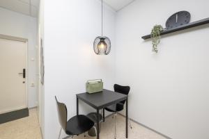 a black table with chairs and a clock on the wall at loond Stay- Kehra Ärimaja in Kekra +2 photos