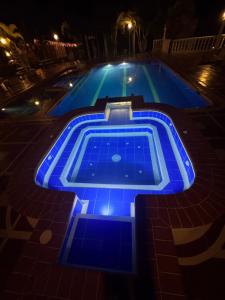 a swimming pool lit up in blue lights at night at Cabitat Cabañas in Quimbaya