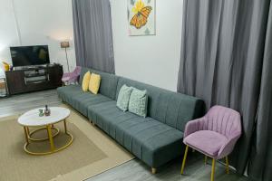 a living room with a green couch and two purple chairs at Casa Mutya in Dauis
