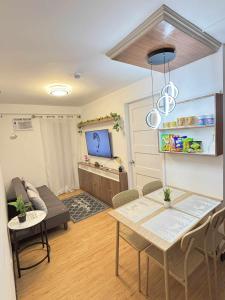 a living room with a table and a tv at Arezzo Place Davao in Davao City