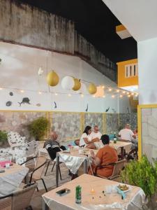 a group of people sitting at tables in a restaurant at Pousada Bella Maré in Goiana