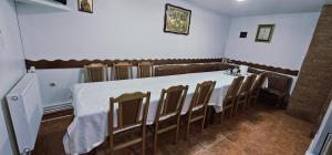 a dining room with a white table and chairs at Casa LUMINITA in Cîrlibaba +7 photos