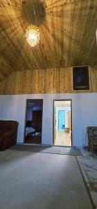 a large room with a wooden ceiling with a chandelier at Casa LUMINITA in Cîrlibaba