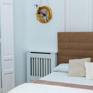 a bedroom with a bed and a clock on the wall at El Refugio de La Condesa Carmen in Manzanares