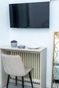 a white table with a chair and a television on a wall at El Refugio de La Condesa Carmen in Manzanares