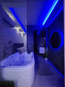 a bathroom with a white tub and blue lighting at Stars lux room in Belgrade +13 photos