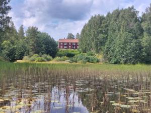 a red building in the middle of a lake at Woxy Prilutta in Voxnabruk