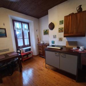 a kitchen with a counter and a table in a room at ANTICA CASA AL LAGO in Oggebbio