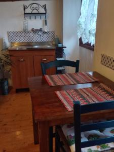 a kitchen with a wooden table with two chairs at ANTICA CASA AL LAGO in Oggebbio +15 photos