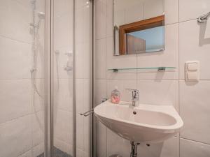 a white bathroom with a sink and a shower at Großvenediger in Mittersill +9 photos
