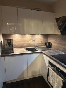 a kitchen with white cabinets and a sink at Deck 8 in Timmendorfer Strand