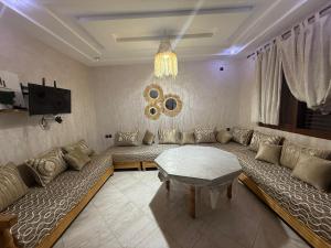 a living room with a large couch and a table at Saidia appart in Saïdia