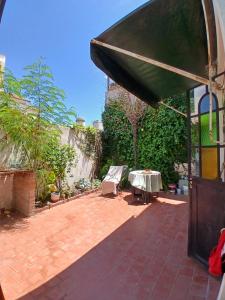 a patio with a table and a green umbrella at Casa Corna in Río Cuarto