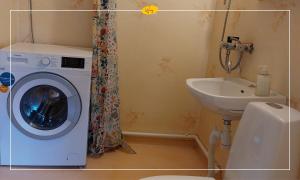a bathroom with a washing machine and a sink at Woxy Prilutta in Voxnabruk