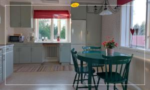 a kitchen with a table and chairs in a kitchen at Woxy Prilutta in Voxnabruk