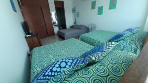 a bedroom with two beds with blue pillows at Apartamento Frente al Mar in Santa Marta +17 photos