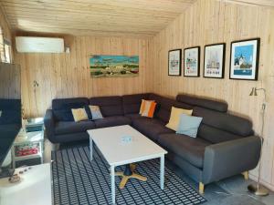a living room with a couch and a table at Home Near Beach With Wilderness Bath in Sindrup +24 photos
