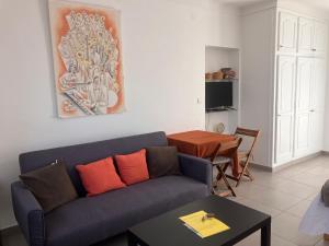 a living room with a blue couch and a table at Studio Mas Pierre in Maureillas