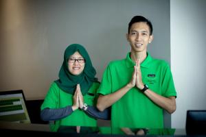 a man and a woman in green doing a gesture at Vinotel Cirebon in Cirebon