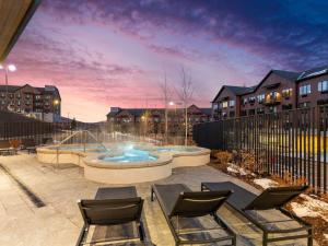 a patio with chairs and a pool with a fence at Pioche Village Park City in Park City