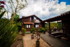 een klein houten gebouw met planten ervoor bij Tombstone in Valle de Bravo