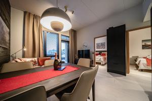 a dining room with a table and a living room at Le Chalet Lingonberry D3 Ski-in Ski-out, Hot Tub by Aavalevi in Levi +24 photos