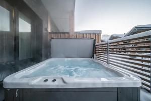 a large bath tub sitting on top of a balcony at Le Chalet Lingonberry D3 Ski-in Ski-out, Hot Tub by Aavalevi in Levi