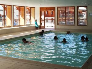 a group of people swimming in a swimming pool at Charmant 2 pièces pour 6 avec piscine, jacuzzi et sauna - Les Orres - FR-1-322-373 in Les Orres