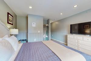a bedroom with a large bed and a flat screen tv at Sea Treasures Inn #101 in Rockaway Beach