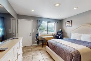 a bedroom with a bed and a desk and a window at Sea Treasures Inn #101 in Rockaway Beach