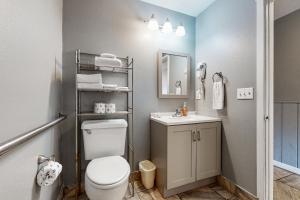 a bathroom with a toilet and a sink and a mirror at Sea Treasures Inn #101 in Rockaway Beach
