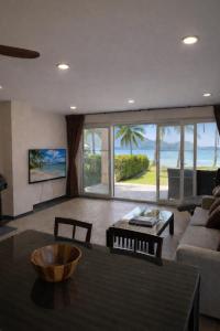 a living room with a view of the ocean at Rosdao Beachfront Villa in Ban Khlong Son