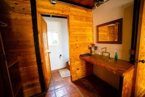 een badkamer met een wastafel en een houten muur bij Tombstone in Valle de Bravo +44 foto's