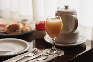 a table with a glass of coffee and a plate of food at Patagonia Hotel in Caleta Olivia +12 photos