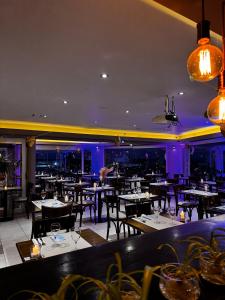 a restaurant with tables and chairs and purple lighting at Patagonia Hotel in Caleta Olivia