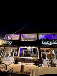 a restaurant with purple lights on the front of it at Patagonia Hotel in Caleta Olivia