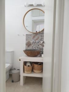 a bathroom with a sink and a mirror at Kalypso Tholos in Astypalaia