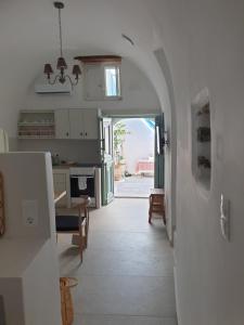 a kitchen with a hallway leading to a dining room at Kalypso Tholos in Astypalaia +9 photos