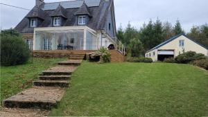 a large house with a large lawn in front of it at Au Pré du Chêne in Le Faouët