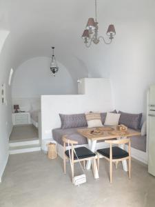 a living room with a table and a couch at Kalypso Tholos in Astypalaia