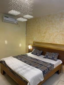 a bedroom with a large bed and a chandelier at Résidence KUYITO in Kaolack