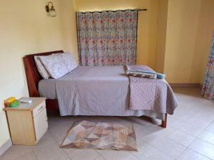 a bedroom with a bed and a dresser and a window at Jugroop Beach House in Baie du Tombeau