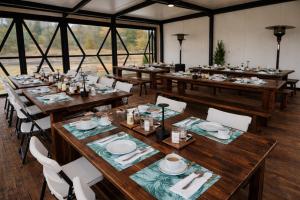 ein Esszimmer mit Holztischen und Stühlen in der Unterkunft DenHills in Denxhi