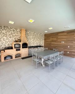 a dining room with a table and a brick oven at House in Jaconé in Maricá